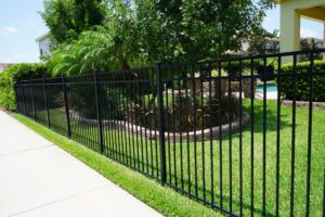 black metal fence surrounding pool and house