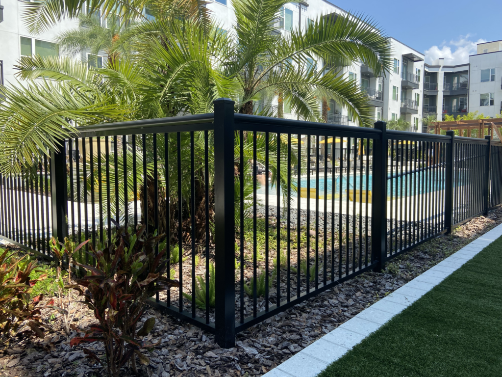 black metal fence surrounding apartment complex pool