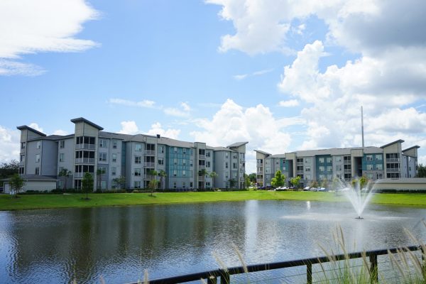 two apartment buildings with lake in front